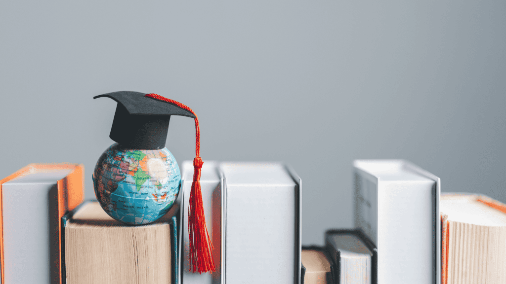 A small globe wearing a graduation cap with a red tassel