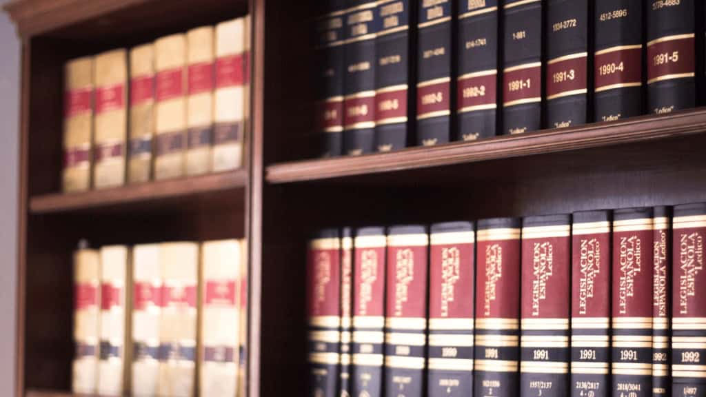 A close-up image of legal books and law references on a wooden bookshelf