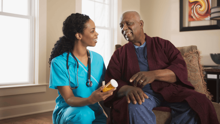 Nurse discussing medication with elderly patient in a home setting