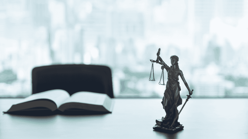 A bronze Lady Justice statue sits on a desk