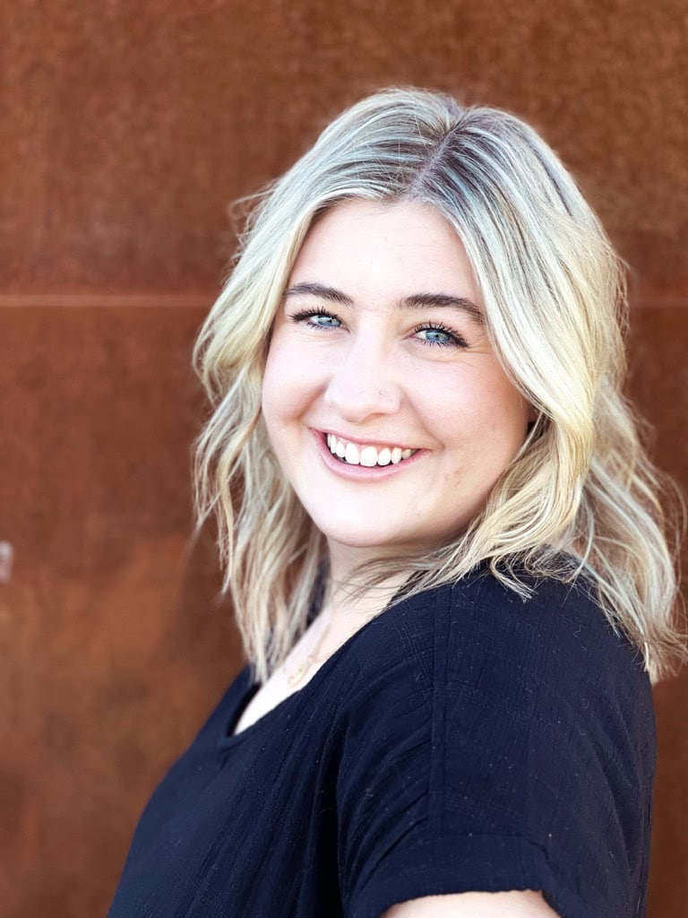 A smiling woman looks at the camera