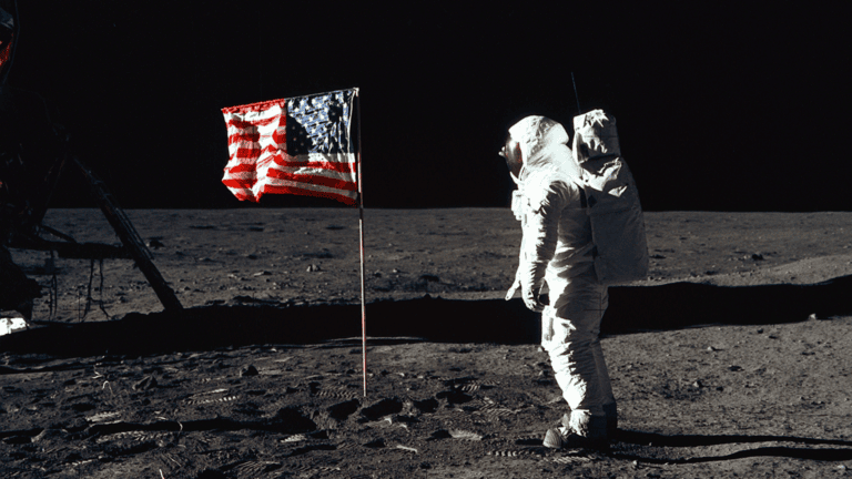 Astronaut by the American flag on the moon's surface