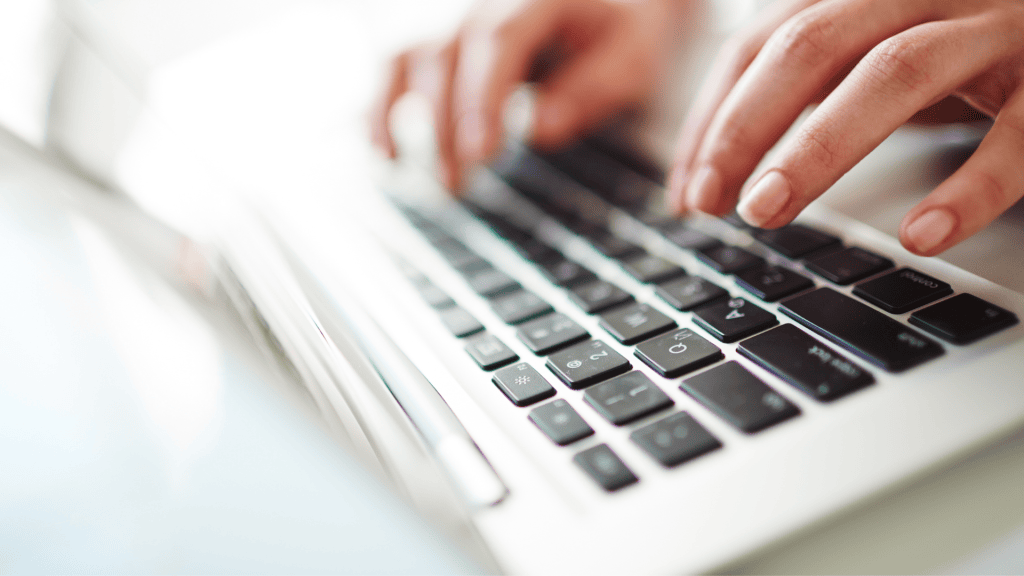 a person typing on a laptop keyboard