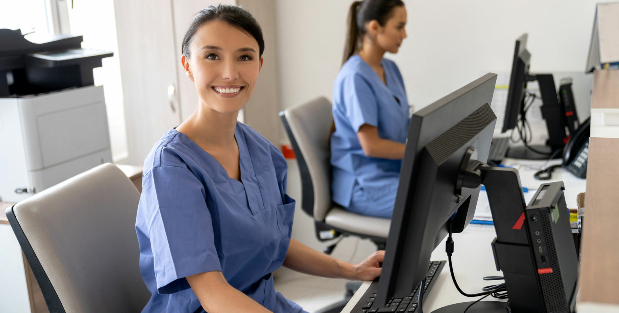 Medical Billing and Coding Undergraduate Certificate Hero Image of a Professional Woman Smiling behind Front Desk