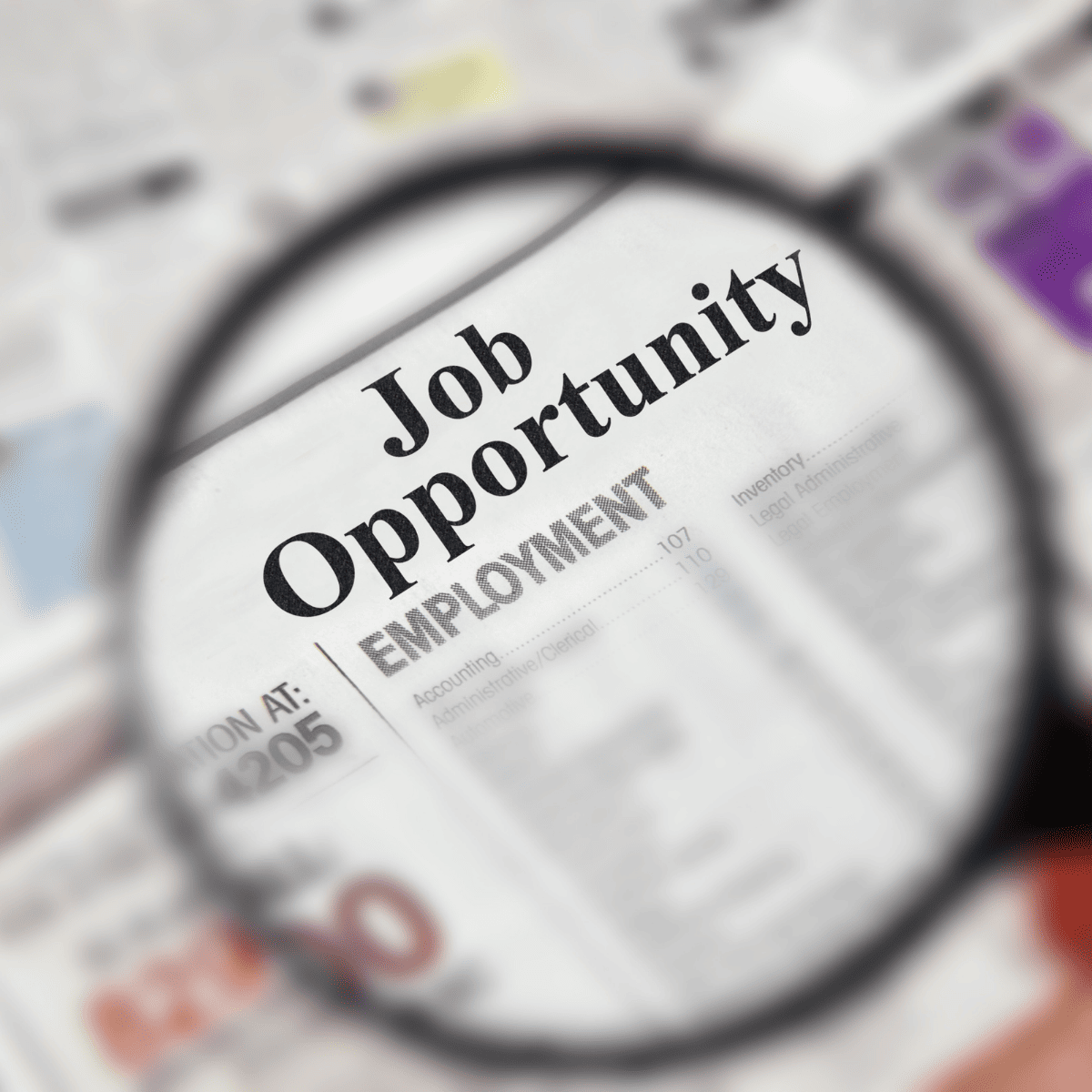 Newspaper article with a magnifying glass showing the words job opportunity large size