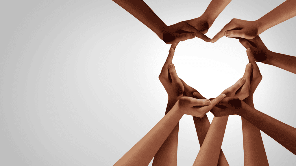 Hands of different skin tones make a heart