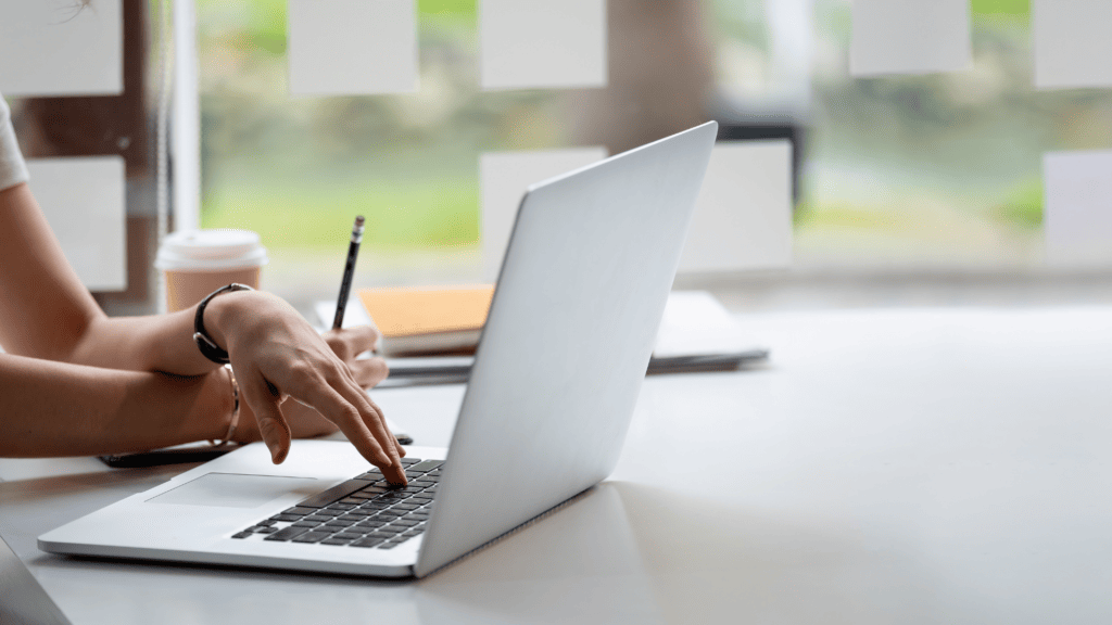 Woman sitting at desk with laptop and pencil taking notes
